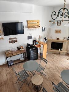 sala de estar con mesas y sillas y TV de pantalla plana en Forese House, en Rivisondoli
