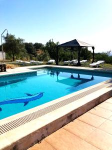 una gran piscina azul con cenador en Finca Villa Coral, en Cazalla de la Sierra