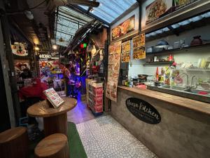 a fast food restaurant with a counter and a table at Hansa Hostel Bangkok Khaosan in Bangkok