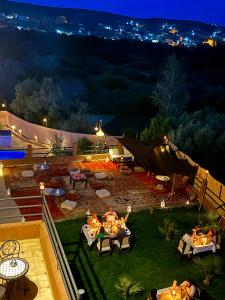 a view of a garden at night with lights at Riad Sahara Stars Dades in Boumalne
