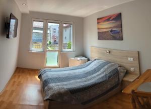 Pokoje Gościnne Bartek في ياستراوبيا جورا: غرفة نوم بسرير كبير ونافذتين