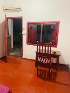 une chambre avec une chaise, une table et une fenêtre dans l'établissement Crystal Bay, à Baie d'Arugam