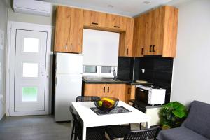 a kitchen with a table with a bowl of fruit on it at Cinque Stelle Apartments in Glida +16 photos