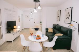 een woonkamer met een bank en een tafel en stoelen bij Piso compartido Delyrent, SFJ in Jaén
