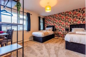 a hotel room with two beds and a table at Newly refurb 3 bed with parking in Stockton-on-Tees