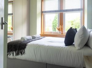 a bedroom with a bed with pillows and a window at Stock Street Apartment in Paisley