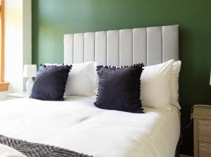 a bedroom with a large white bed with blue pillows at Stock Street Apartment in Paisley