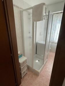 a bathroom with a glass shower with a sink at Appartamento Villa Asio in Lignano Sabbiadoro