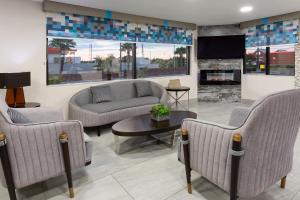 a waiting room with couches and a fireplace at Super 8 by Wyndham Prattville Montgomery in Prattville