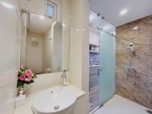 La salle de bains est pourvue d'un lavabo et d'une douche. dans l'établissement Hanoi Home 2 - Lake View Apartment, à Hanoï