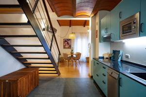 une cuisine avec un escalier menant à un salon dans l'établissement Dúplex apartamento Godoy Centro, à Cáceres