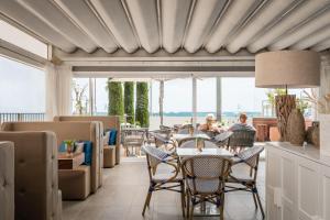 ein Wohnzimmer mit einem Tisch und Stühlen in der Unterkunft ALEGRIA Mar Mediterrania - Adults Only 4*Sup in Santa Susanna