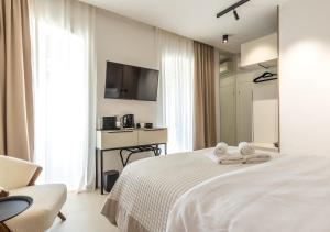 een slaapkamer met een bed, een stoel en een televisie bij Teuta Garden Luxury Room in Split