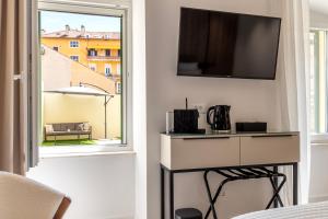 een kamer met een raam en een tv aan de muur bij Teuta Garden Luxury Room in Split