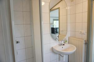 a bathroom with a sink and a mirror at Kustverhuur, 't Uusje Nieuwvliet in Nieuwvliet +10 photos