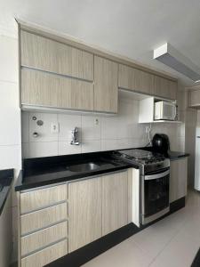 a kitchen with a stove and a microwave at Apartamentos Liberdade São Paulo Center in Sao Paulo