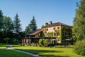 an old house with ivy on it on a lawn at Locanda Sandi in Valdobbiadene