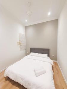 ein Schlafzimmer mit einem großen weißen Bett mit weißen Kissen in der Unterkunft Spacious Corner Landed House Golden Hills Night Market in Brinchang