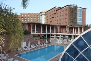 a hotel swimming pool with chairs and a building at Hotel Asmara Palace in Asmara