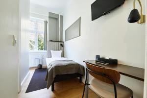 哥本哈根的住宿－斯卡特托馬斯酒店，客房设有书桌、椅子和床。