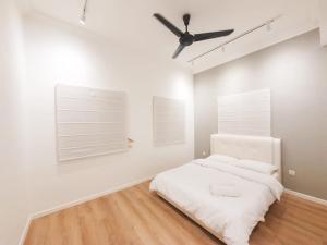 biała sypialnia z łóżkiem i wentylatorem sufitowym w obiekcie Spacious Corner Landed House Golden Hills Night Market w mieście Brinchang