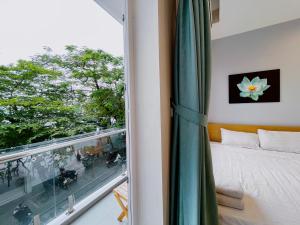 sypialnia z łóżkiem i dużym oknem w obiekcie Hanoi Home 2 - Lake View Apartment w mieście Hanoi