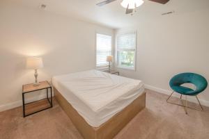 1 dormitorio con 1 cama y 1 silla azul en Sun Outdoors Cape May en Cape May