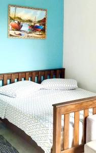 a bedroom with a bed with a picture on the wall at FLAT / APARTAMENTO NA PRAIA DO FORTE in Cabo Frio