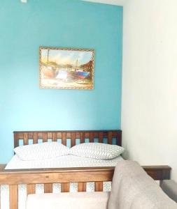um quarto com uma cama com uma parede azul em FLAT / APARTAMENTO NA PRAIA DO FORTE em Cabo Frio