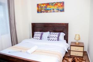a bedroom with a bed and a painting on the wall at Comfort & Style 1Bed Apartment, Luxore, Syokimau in Nairobi
