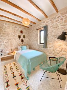 a bedroom with a bed and a chair at Kaouki Lodge in Sidi Kaouki +22 photos