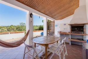 a patio with a table and chairs and a fireplace at Sesmarias MEL Casas Gémeas para Famílias Grandes in Cercal