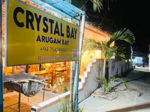 una señal amarilla delante de un restaurante en Crystal Bay en Arugam Bay