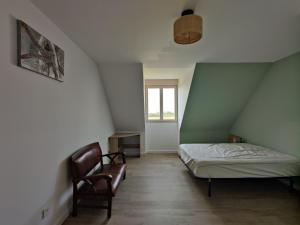 a small bedroom with a bed and a chair at Camping la Haie Penée **** in Saint-Quentin-en-Tourmont +80 photos