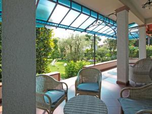 eine Terrasse mit Korbstühlen und einem Glasdach in der Unterkunft Villa Lavinia by Interhome in Forte dei Marmi