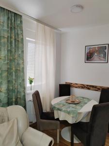 un soggiorno con tavolo da pranzo e sedie di Apartman SM a Sremska Mitrovica