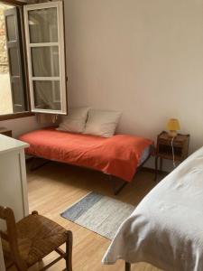 a room with a bench with a window and a bed at Les 3 balcons in Prades