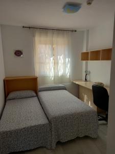 a bedroom with two beds and a desk and a window at Apartamento Golf in Roquetas de Mar +15 photos
