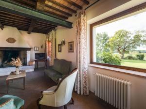 sala de estar con chimenea y ventana grande en Holiday Home Poggio Campana by Interhome, en Montemerano