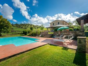 un patio trasero con piscina y una casa en Holiday Home Poggio Campana by Interhome, en Montemerano