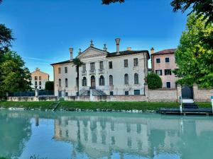 un vieux bâtiment à côté d'une masse d'eau dans l'établissement ERMAN HOUSE Mansarda sulla Riviera del Brenta Venezia, à Dolo