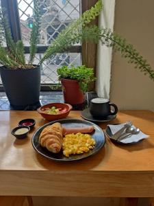 a table with a plate of breakfast food on a table at Suite Eugenia ubicada en el centro de Estreno in Cuenca