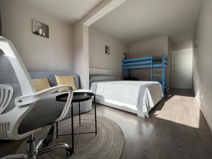 1 dormitorio con 1 cama y 1 silla en Camp Nou Nueva Casa, en El Arrabal