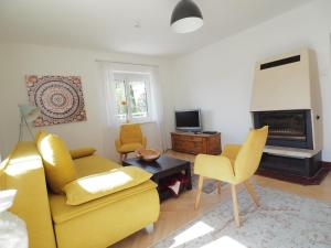 ein Wohnzimmer mit einem gelben Sofa und einem Kamin in der Unterkunft Haus Sunnseitn in Innsbruck