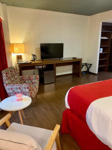 una camera d'albergo con letto e scrivania con TV di First Palermo Hotel a Buenos Aires