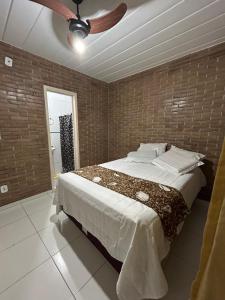 a bedroom with a bed and a ceiling fan at Casa agradável em um condomínio na barra do sana. in Sana