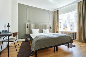1 dormitorio con cama, escritorio y ventana en Hotel Sct. Thomas en Copenhague