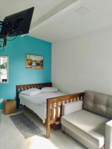 um quarto com uma cama e um sofá em FLAT / APARTAMENTO NA PRAIA DO FORTE em Cabo Frio