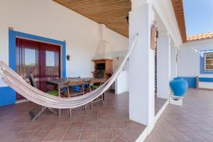 a hammock in the living room of a house at Sesmarias MEL Casas Gémeas para Famílias Grandes in Cercal