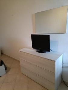 a flat screen tv sitting on top of a desk at Gelsi Holiday Home La Maddalena in La Maddalena +17 photos